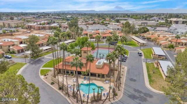 an aerial view of a swimming pool with a yard and mountain view