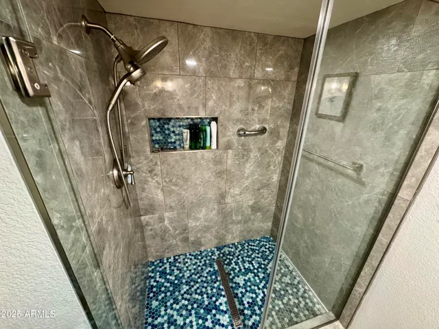a en suite bathroom with a sink double vanity granite and a mirror