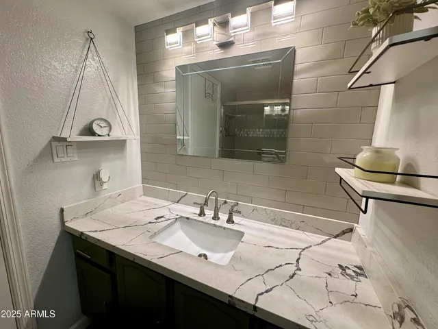 a bathroom with a granite countertop toilet sink and mirror