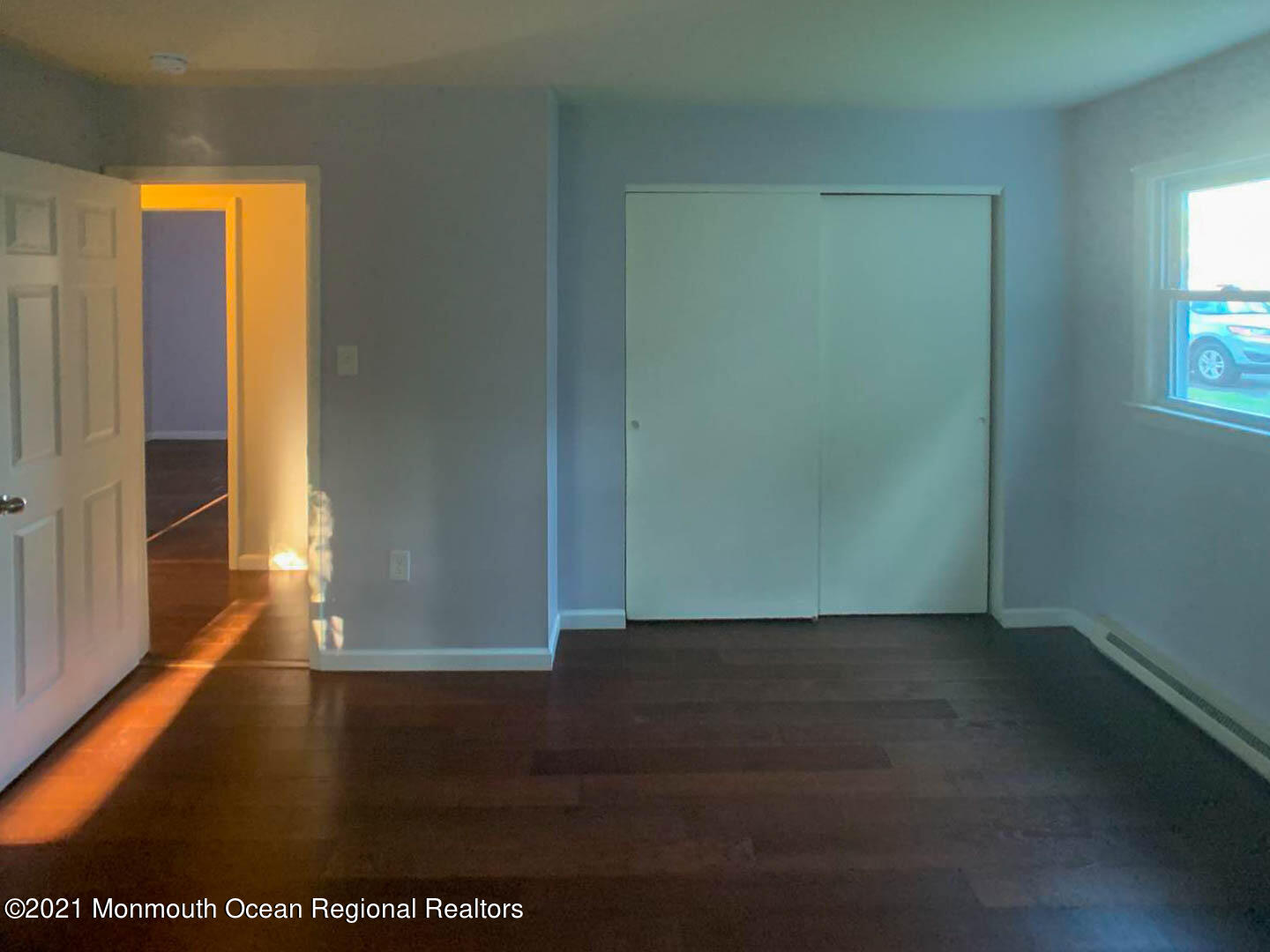 109 Beverly Drive Barnegat, NJ 08005 - Photo 17 of 20 an empty room with wooden floor and windows with curtains