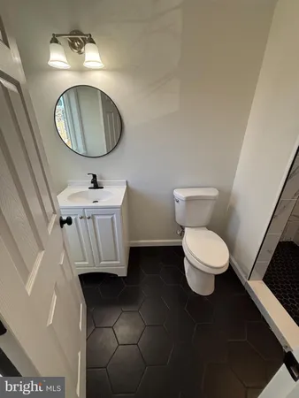 a bathroom with a toilet sink mirror and vanity
