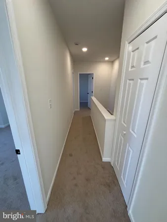 a view of a hallway with wooden floor and entryway