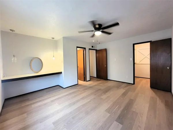 a view of an empty room with window and wooden floor