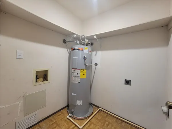 a view of storage and utility room with refrigerator and mirror