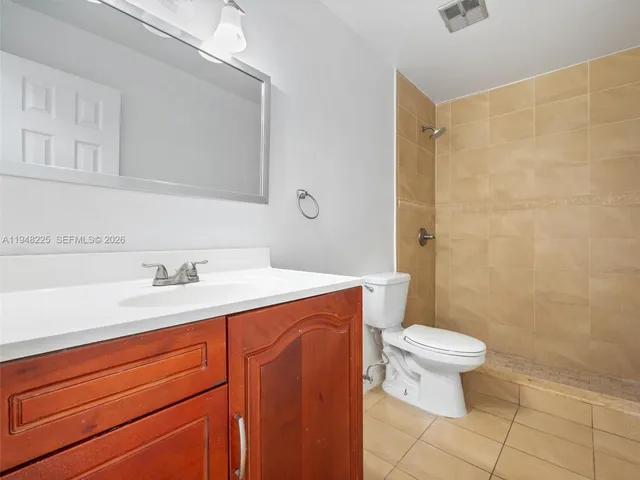 a bathroom with a granite countertop sink a toilet and a mirror