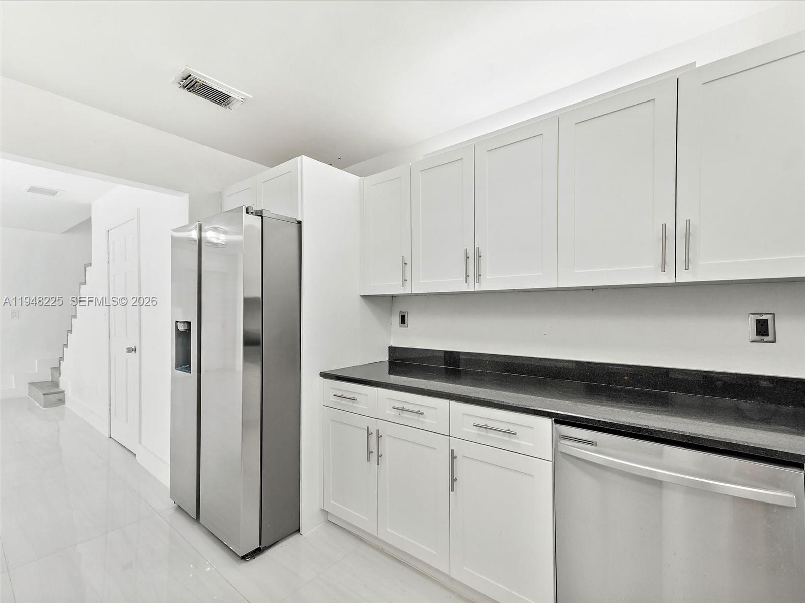 13841 Southwest 17th Terrace Miami, FL 33175 - Photo 16 of 31 a kitchen with granite countertop white cabinets and refrigerator