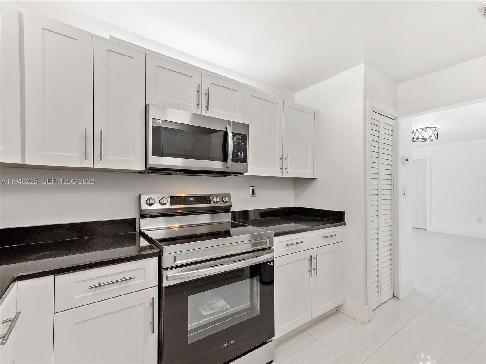 13841 Southwest 17th Terrace Miami, FL 33175 - Photo 17 of 31 a kitchen with granite countertop white cabinets and stainless steel appliances