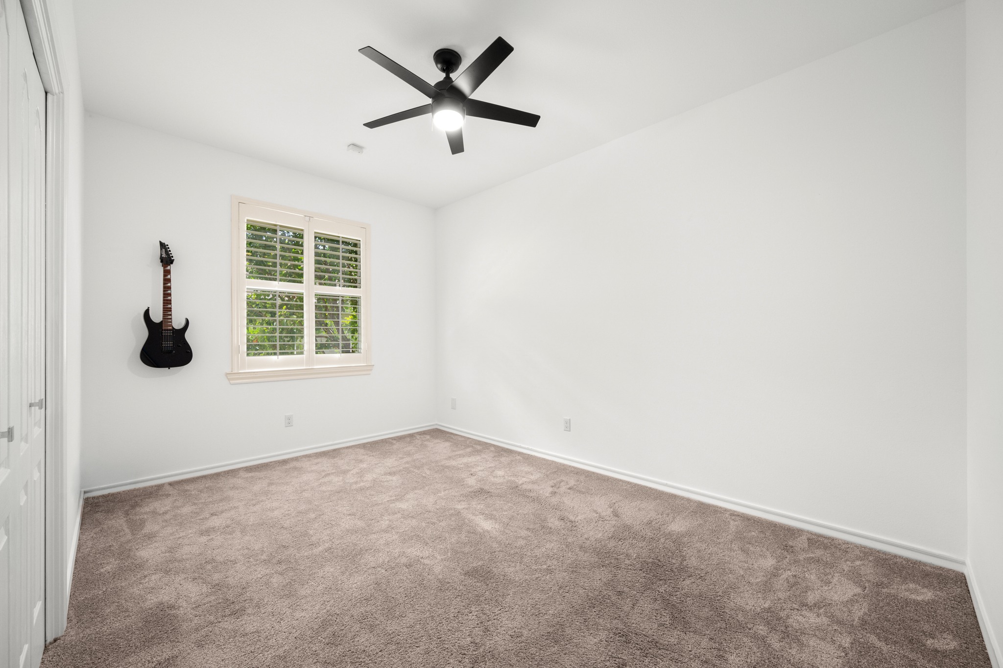 30115 Sawgrass Trail Georgetown, TX 78628 - Photo 14 of 37 A well-lit bedroom features plush carpeting and a modern ceiling fan, perfect for a cozy retreat.