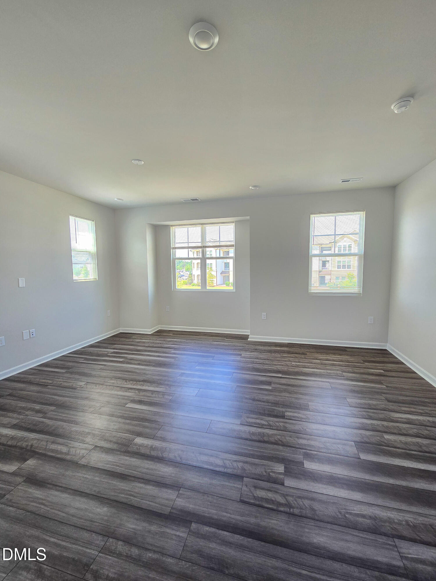 2431 Kasota Lane Raleigh, NC 27610 - Photo 17 of 46 an empty room with wooden floor and windows