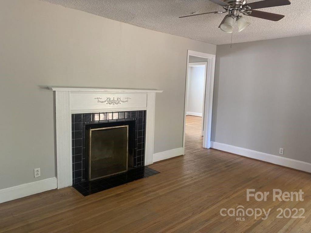 725 Tom Sadler Road Charlotte, NC 28214 - Photo 5 of 9 a view of a livingroom with a fireplace and a ceiling fan