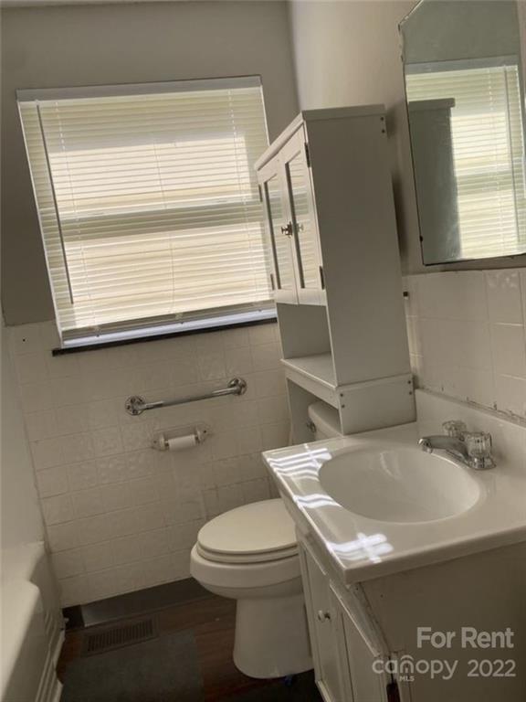 725 Tom Sadler Road Charlotte, NC 28214 - Photo 6 of 9 a bathroom with a sink a toilet and a mirror