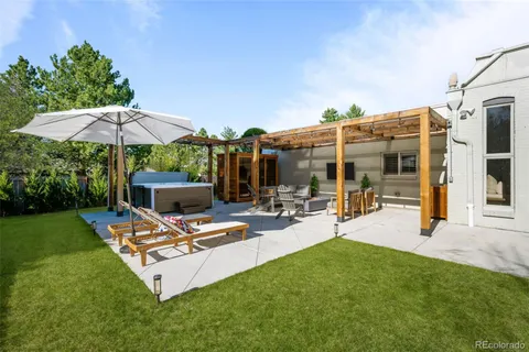 a view of a patio with chairs and table under an umbrella