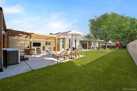 a view of a patio with table and chairs potted plants and large tree