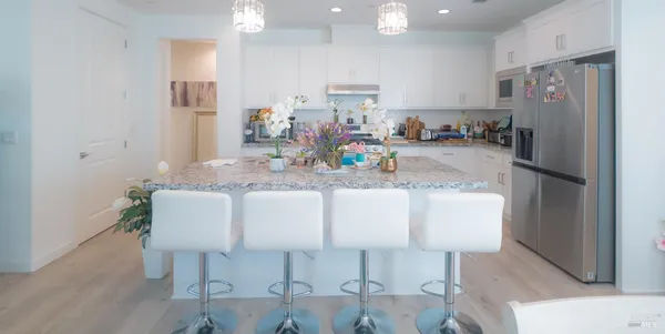 a kitchen with stainless steel appliances granite countertop a refrigerator and a sink