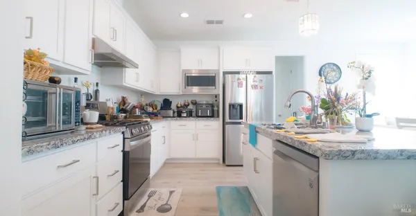 a kitchen with stainless steel appliances granite countertop a sink stove and cabinets