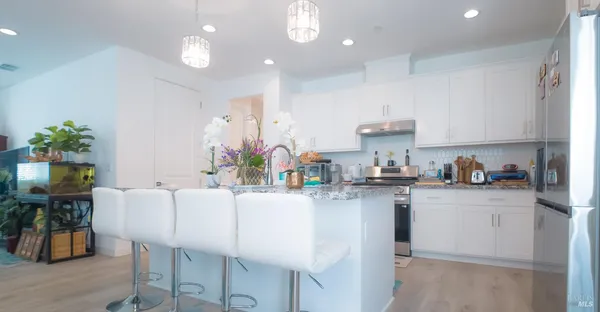 a kitchen with stainless steel appliances granite countertop a sink a stove and a refrigerator