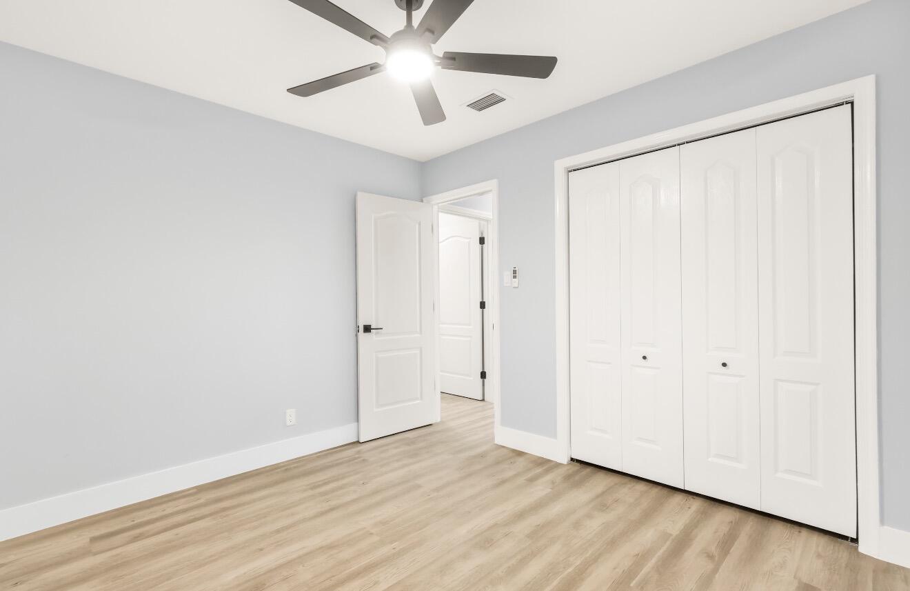 6717 Northwest 60th Street Tamarac, FL 33321 - Photo 16 of 26 an empty room with wooden floor closet and fan