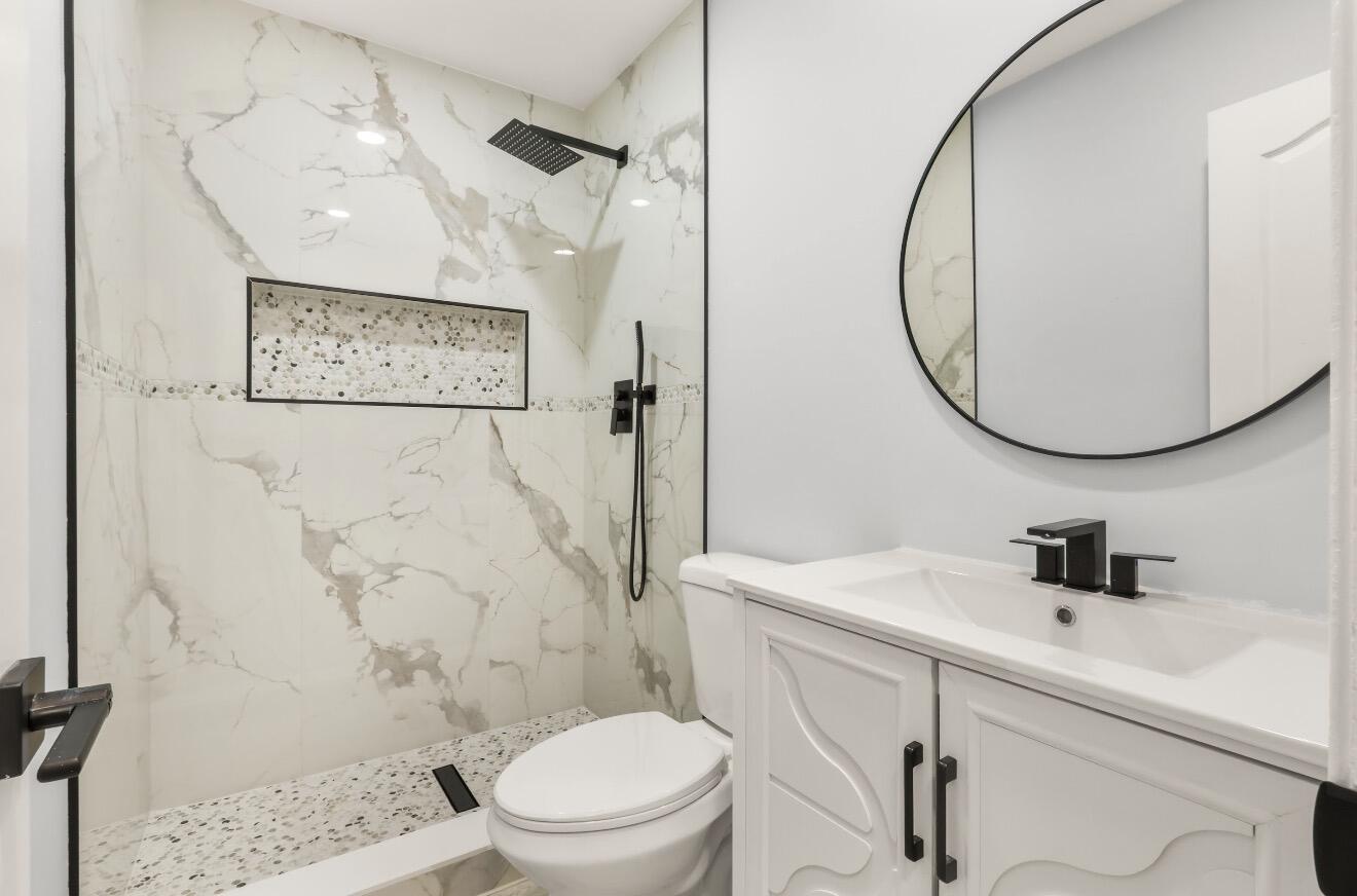 6717 Northwest 60th Street Tamarac, FL 33321 - Photo 22 of 26 a bathroom with a toilet sink and a mirror