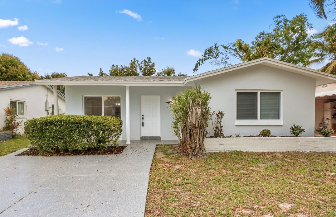 6717 Northwest 60th Street Tamarac, FL 33321 - Photo 23 of 26 a front view of a house with garden