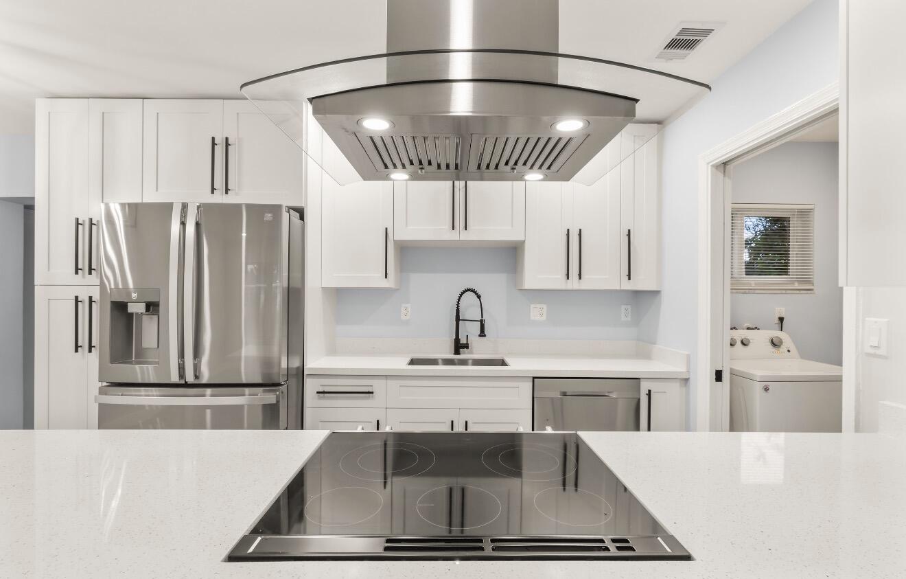 6717 Northwest 60th Street Tamarac, FL 33321 - Photo 6 of 26 a kitchen with stainless steel appliances a stove a sink and a refrigerator