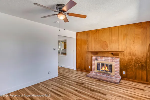 a view of a room with wooden floor and a ceiling fan