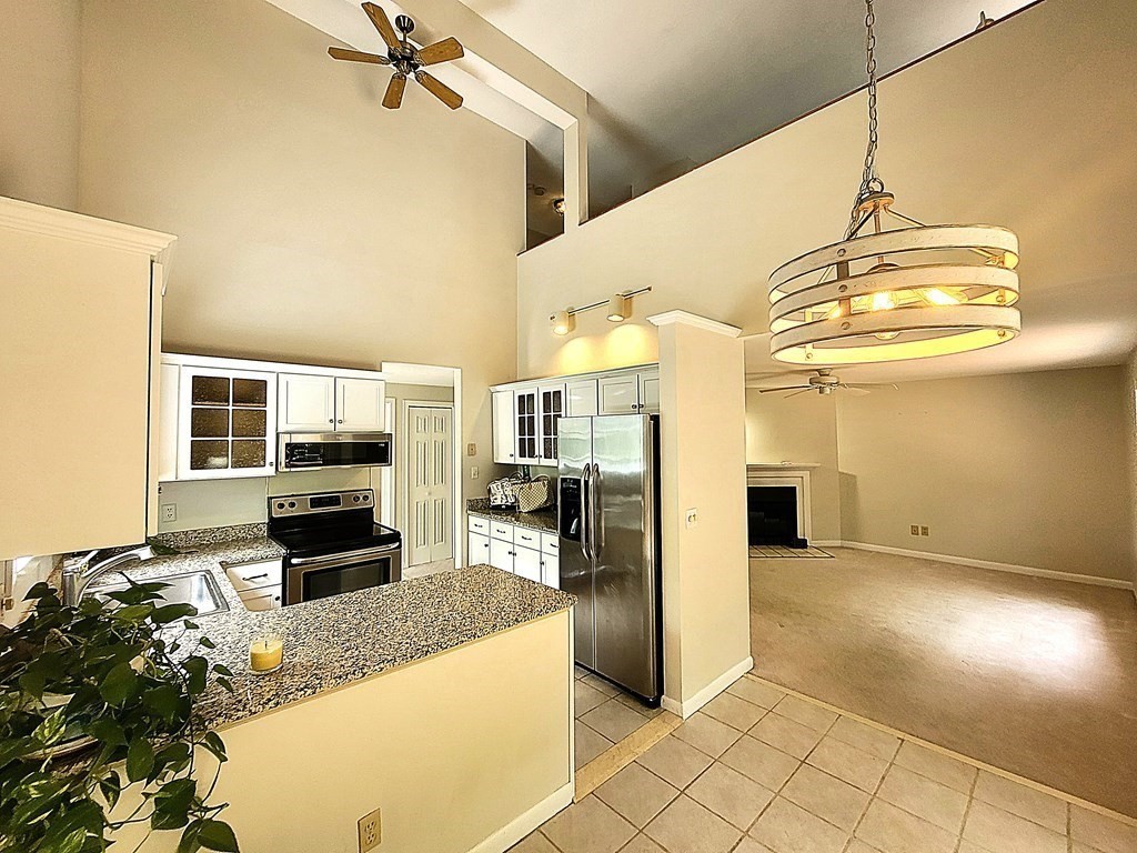 105 Shellback Way, Unit 105 Mashpee, MA 02649 - Photo 4 of 26 a kitchen with stainless steel appliances granite countertop a refrigerator and a stove