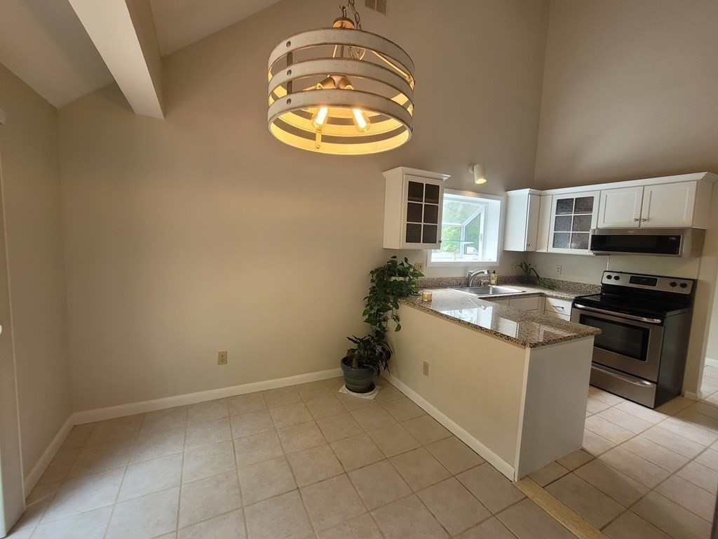 105 Shellback Way, Unit 105 Mashpee, MA 02649 - Photo 5 of 26 a kitchen with stainless steel appliances granite countertop a sink and a stove