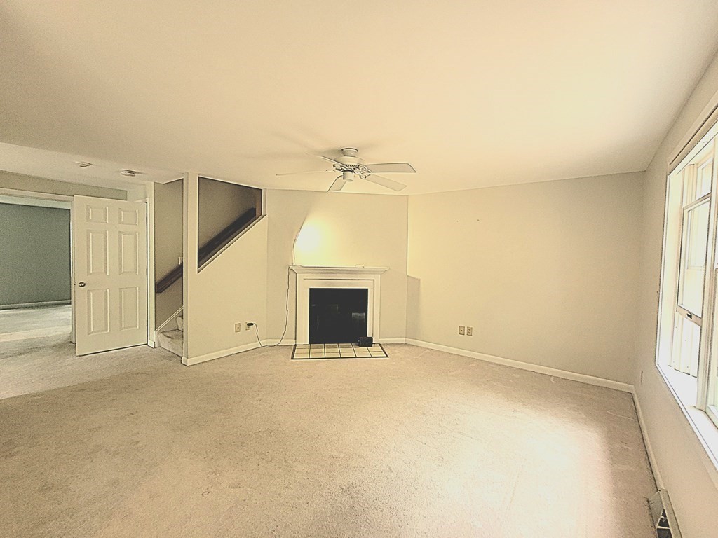 105 Shellback Way, Unit 105 Mashpee, MA 02649 - Photo 8 of 26 an empty room with a fireplace and a window