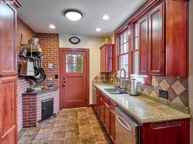 a kitchen with stainless steel appliances granite countertop a stove a sink and a microwave
