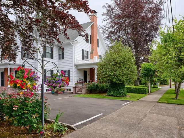 a front view of a house with a yard and a tree
