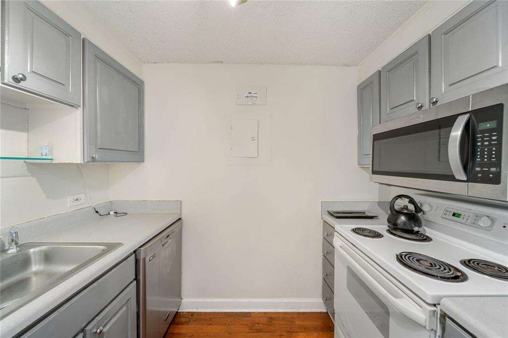 375 Ralph McGill Boulevard Northeast, Unit 1402 Atlanta, GA 30312 - Photo 12 of 17 a kitchen with a sink stove and cabinets