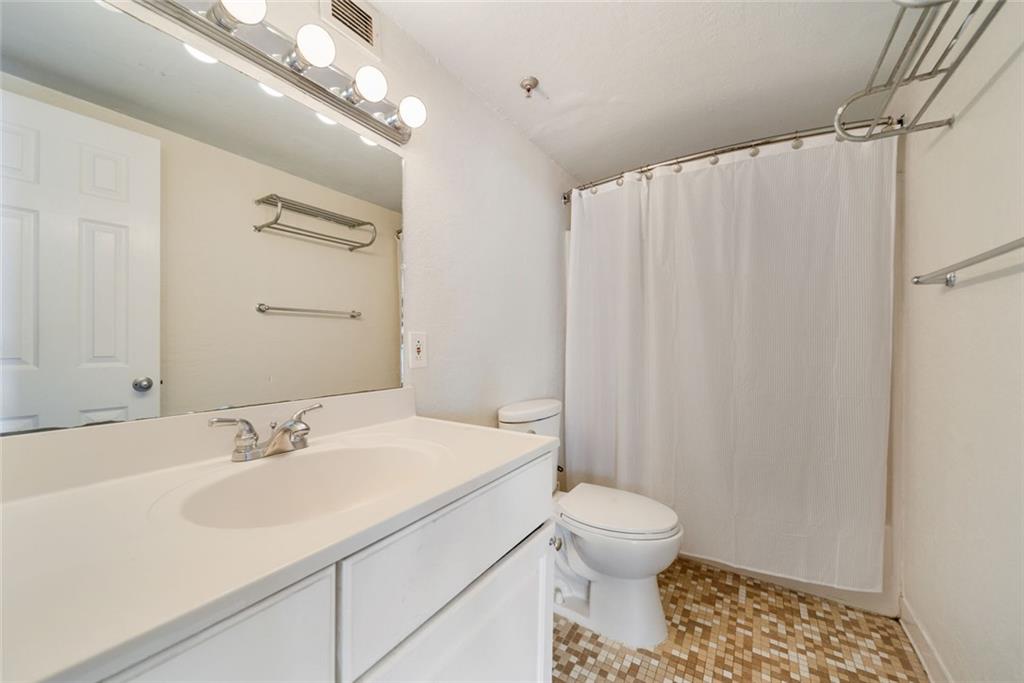 375 Ralph McGill Boulevard Northeast, Unit 1402 Atlanta, GA 30312 - Photo 9 of 17 a bathroom with a sink toilet a mirror and shower