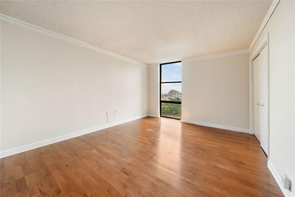 375 Ralph McGill Boulevard Northeast, Unit 1402 Atlanta, GA 30312 - Photo 10 of 17 a view of an empty room with wooden floor and a window
