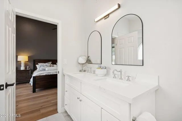 a en suite bathroom with a double vanity sink and a mirror