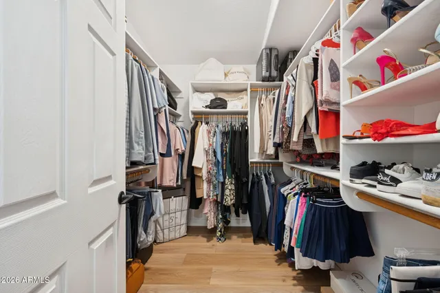 a view of walk in closet with clothes and shoes