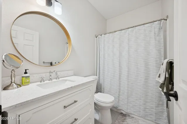 a bathroom with a sink a toilet and a mirror