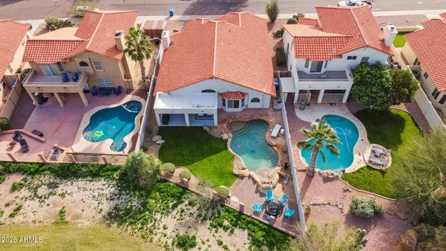 an aerial view of a house with a yard and a large pool
