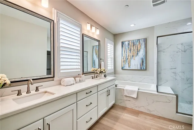 a bathroom with a double vanity sink toilet mirror and bathtub