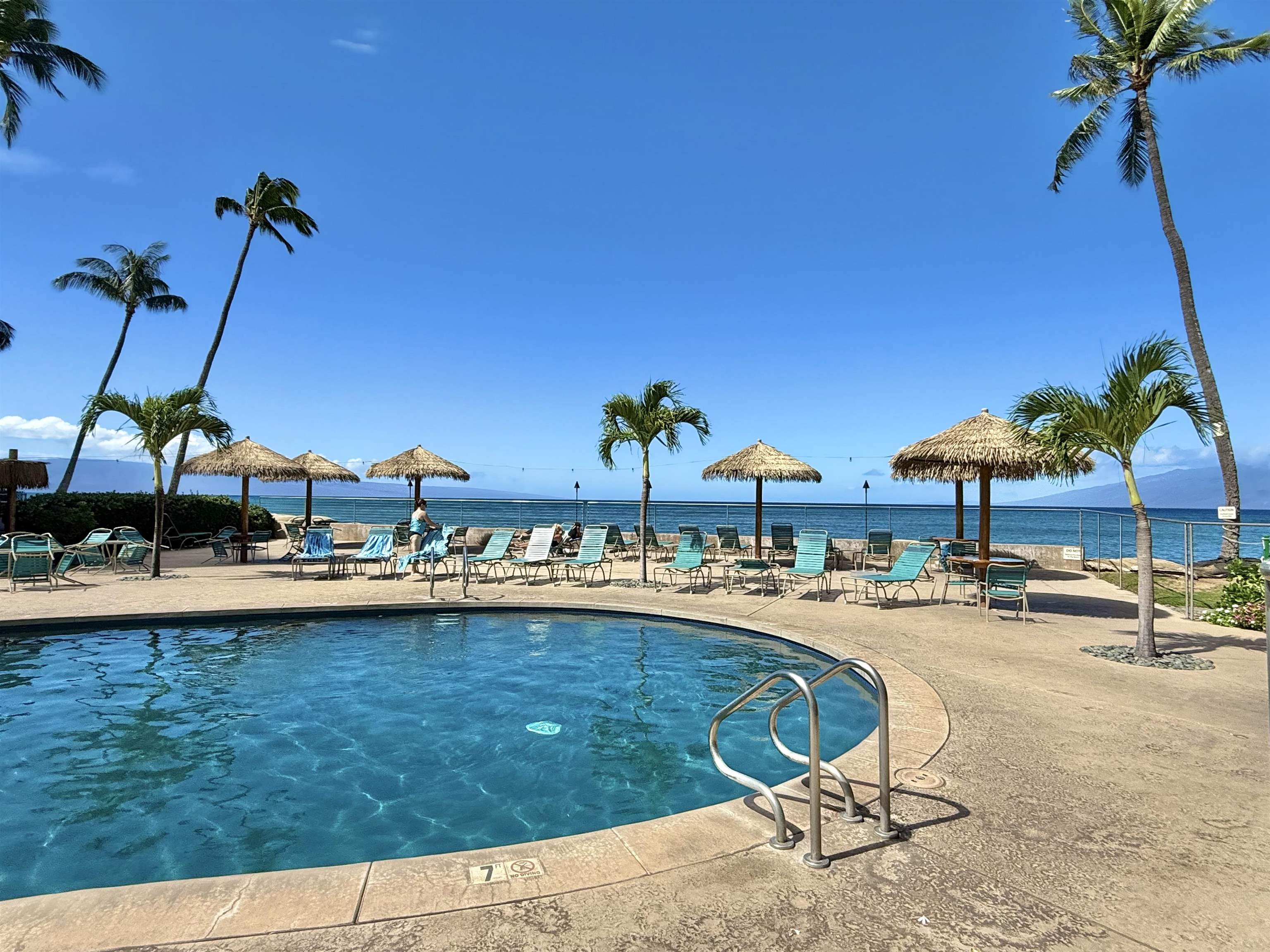 4365 Lower Honoapiilani Road, Unit 801 Lahaina, HI 96761 - Photo 21 of 24 a view of a swimming pool with a table and chairs