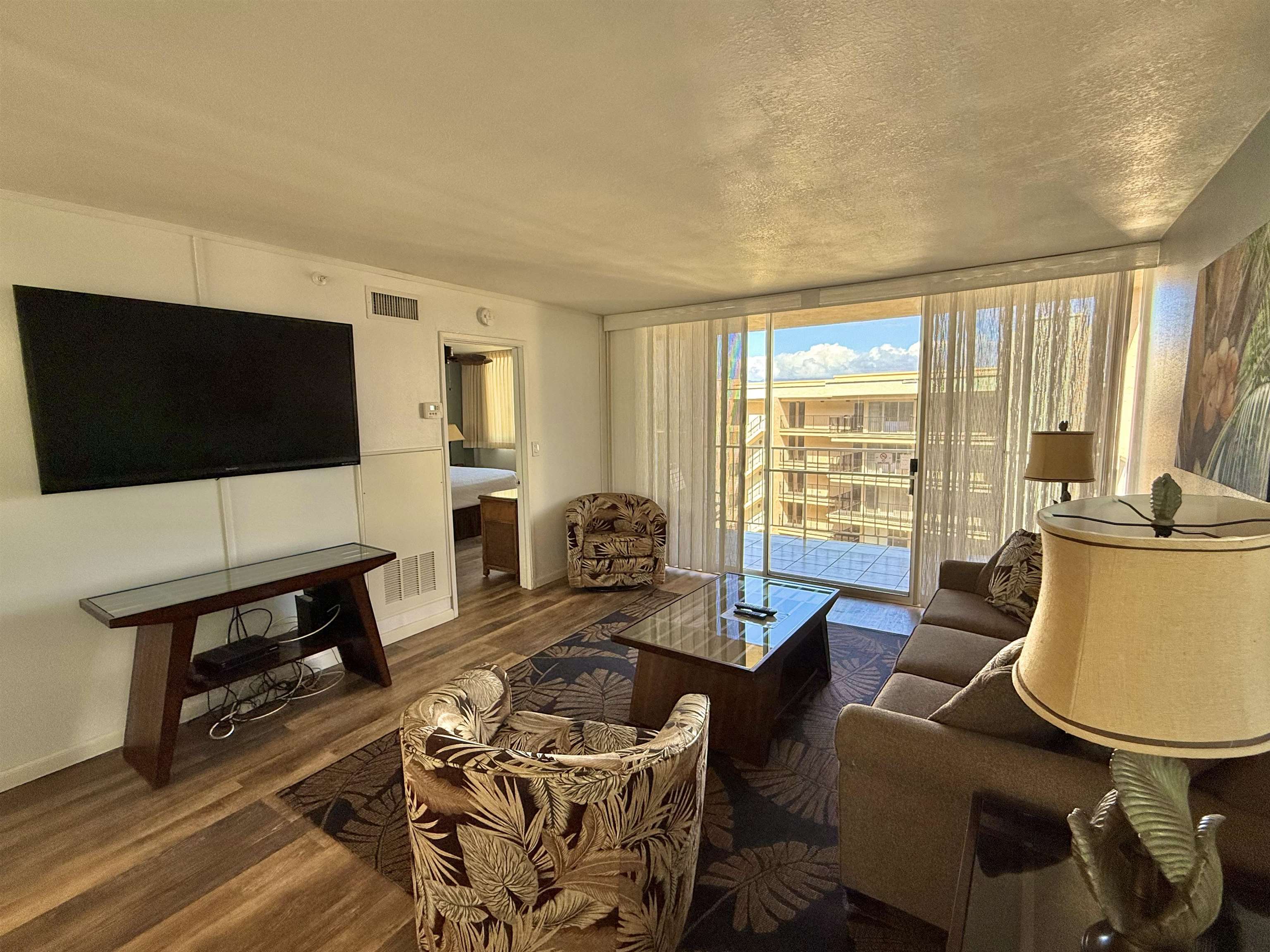 4365 Lower Honoapiilani Road, Unit 801 Lahaina, HI 96761 - Photo 5 of 24 a living room with furniture a flat screen tv and a large window