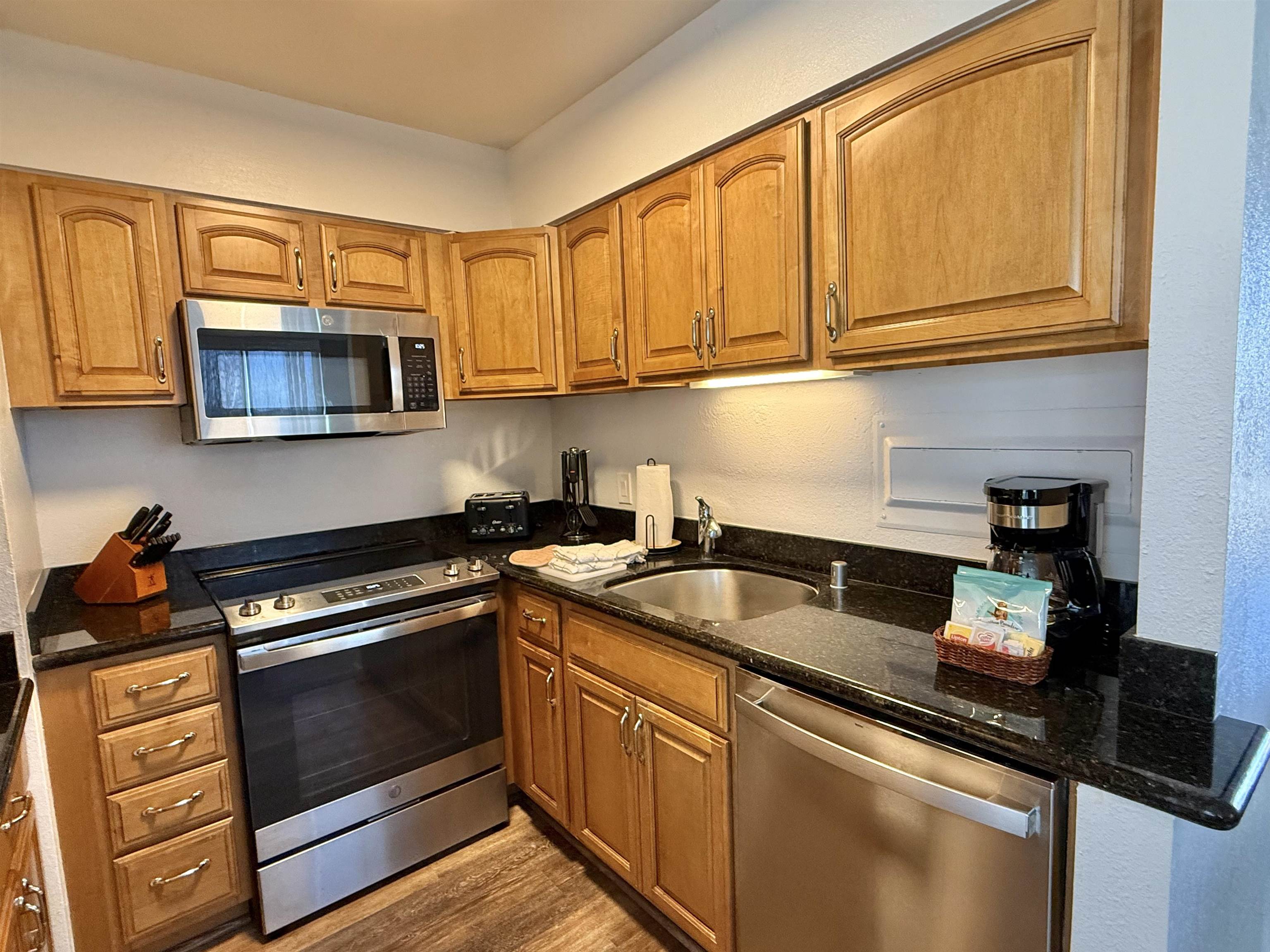 4365 Lower Honoapiilani Road, Unit 801 Lahaina, HI 96761 - Photo 10 of 24 a kitchen with stainless steel appliances granite countertop a sink stove and microwave