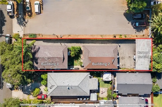 an aerial view of residential houses with outdoor space and parking