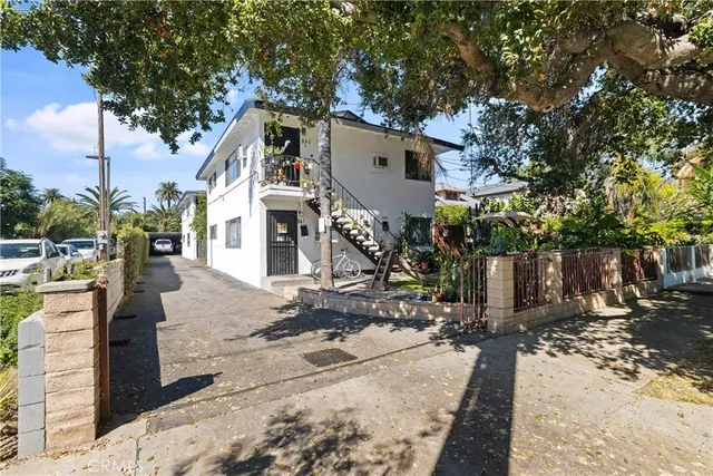 a front view of a house with a tree