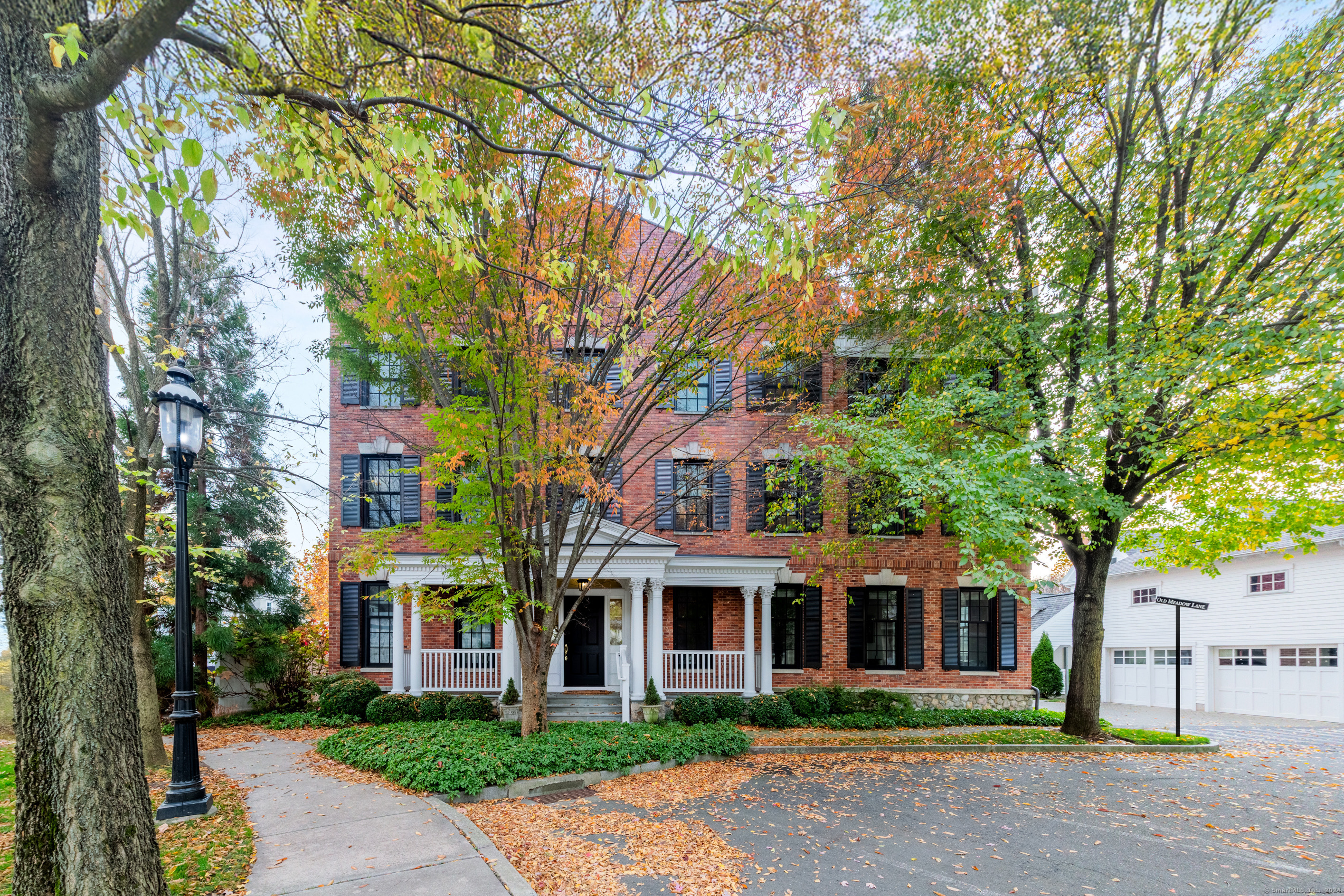 51 Elmwood Drive Fairfield, CT 06890 - Photo 1 of 1 front view of a brick house next to a yard with large trees