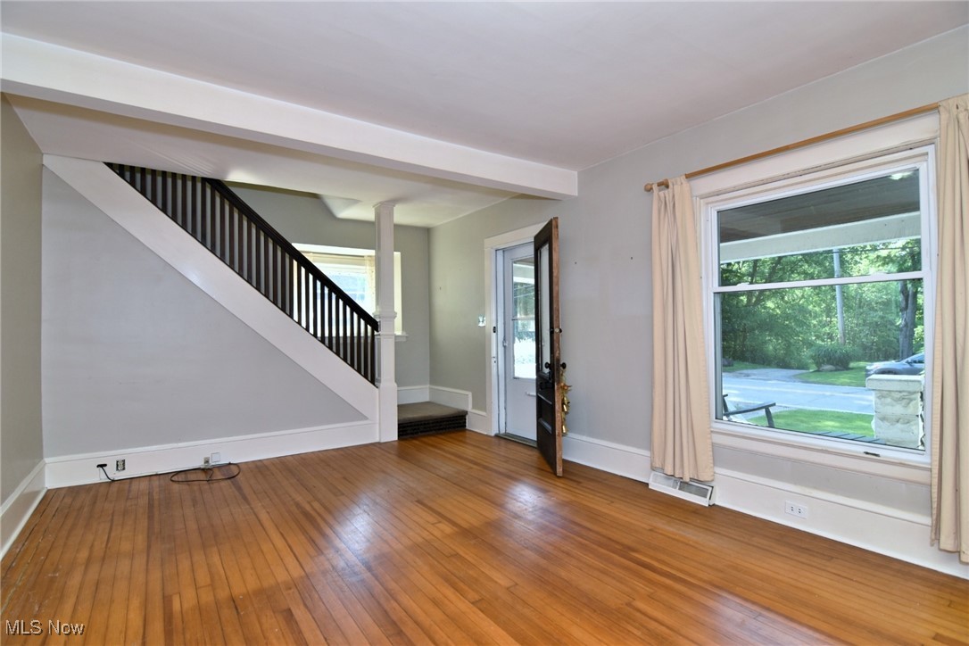 272 Miles Road Chagrin Falls, OH 44022 - Photo 7 of 22 Unfurnished room with stairway and wood-type flooring