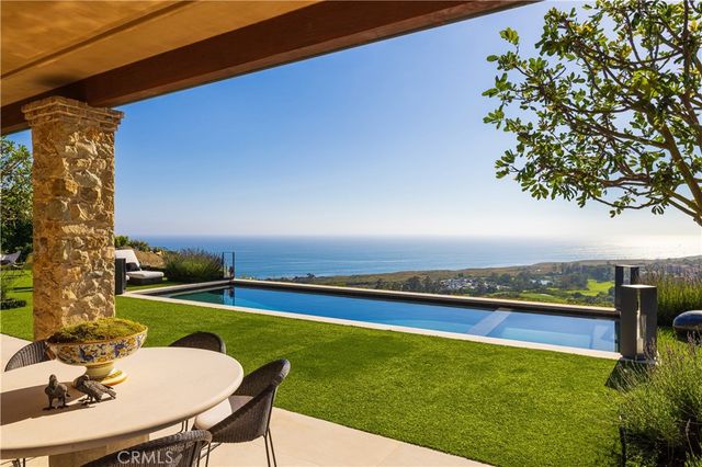a view of a swimming pool with an outdoor seating and a yard