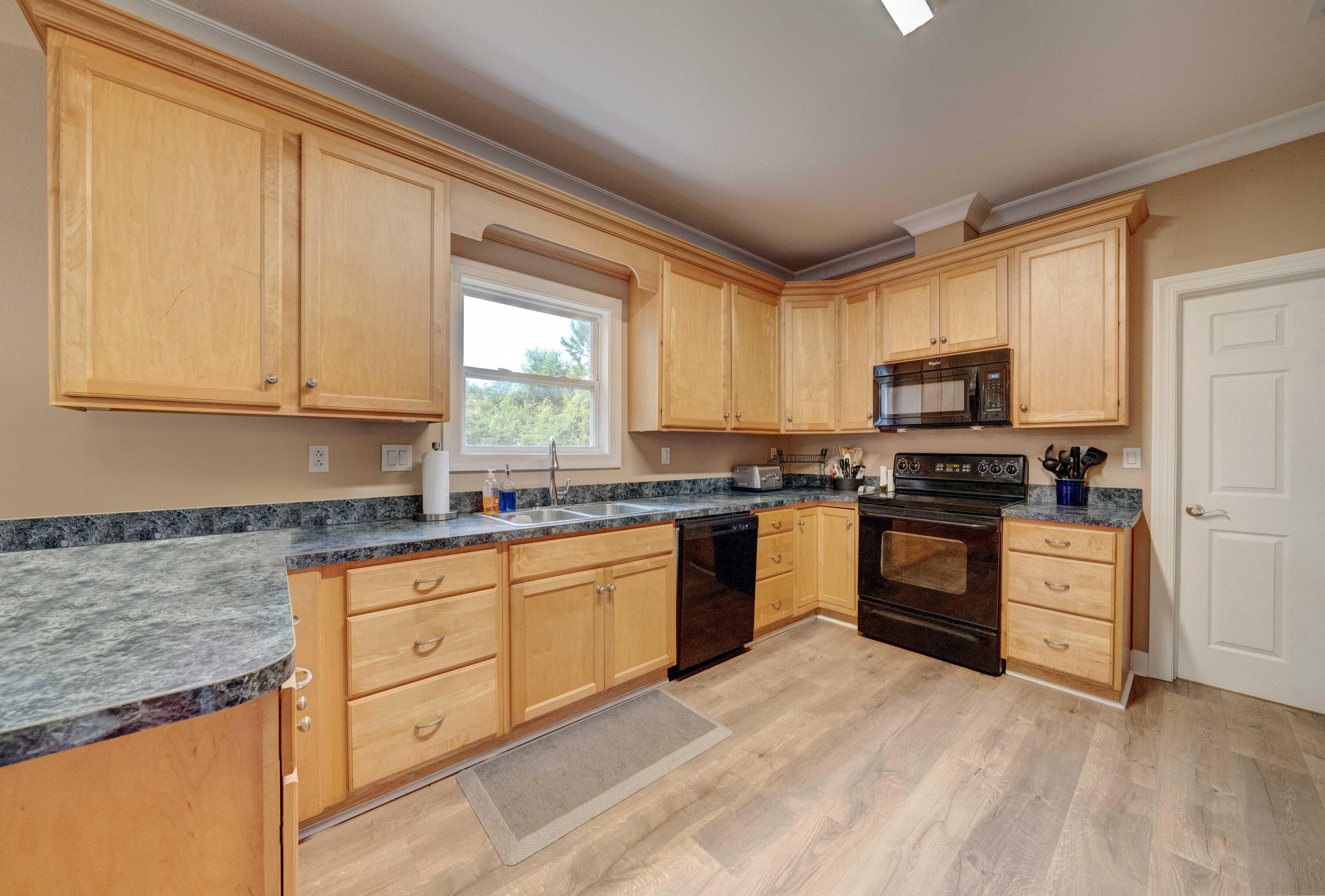 700 Timber Ridge Court Eastpoint, FL 32328 - Photo 8 of 20 a kitchen with granite countertop a stove top oven sink and cabinets