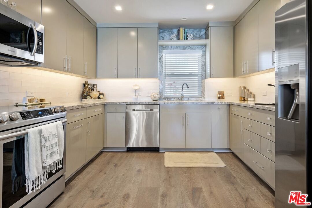 18147 Coastline Drive, Unit 3 Malibu, CA 90265 - Photo 10 of 40 a kitchen with a sink a stove and cabinets