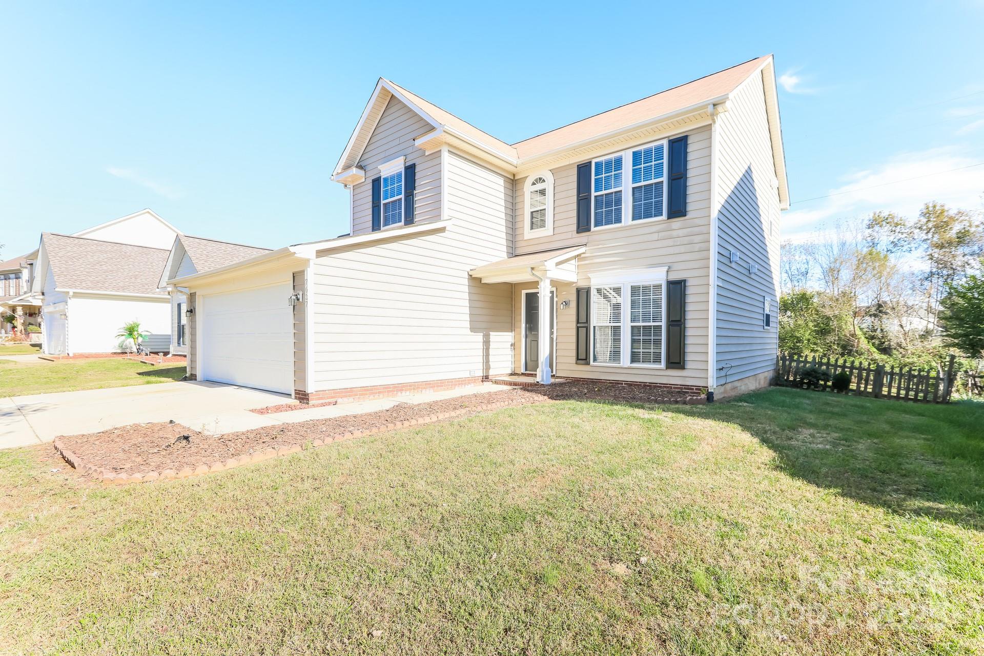 7037 Honey Tree Lane Indian Trail, NC 28079 - Photo 2 of 17 a view of a house with a backyard and a garage