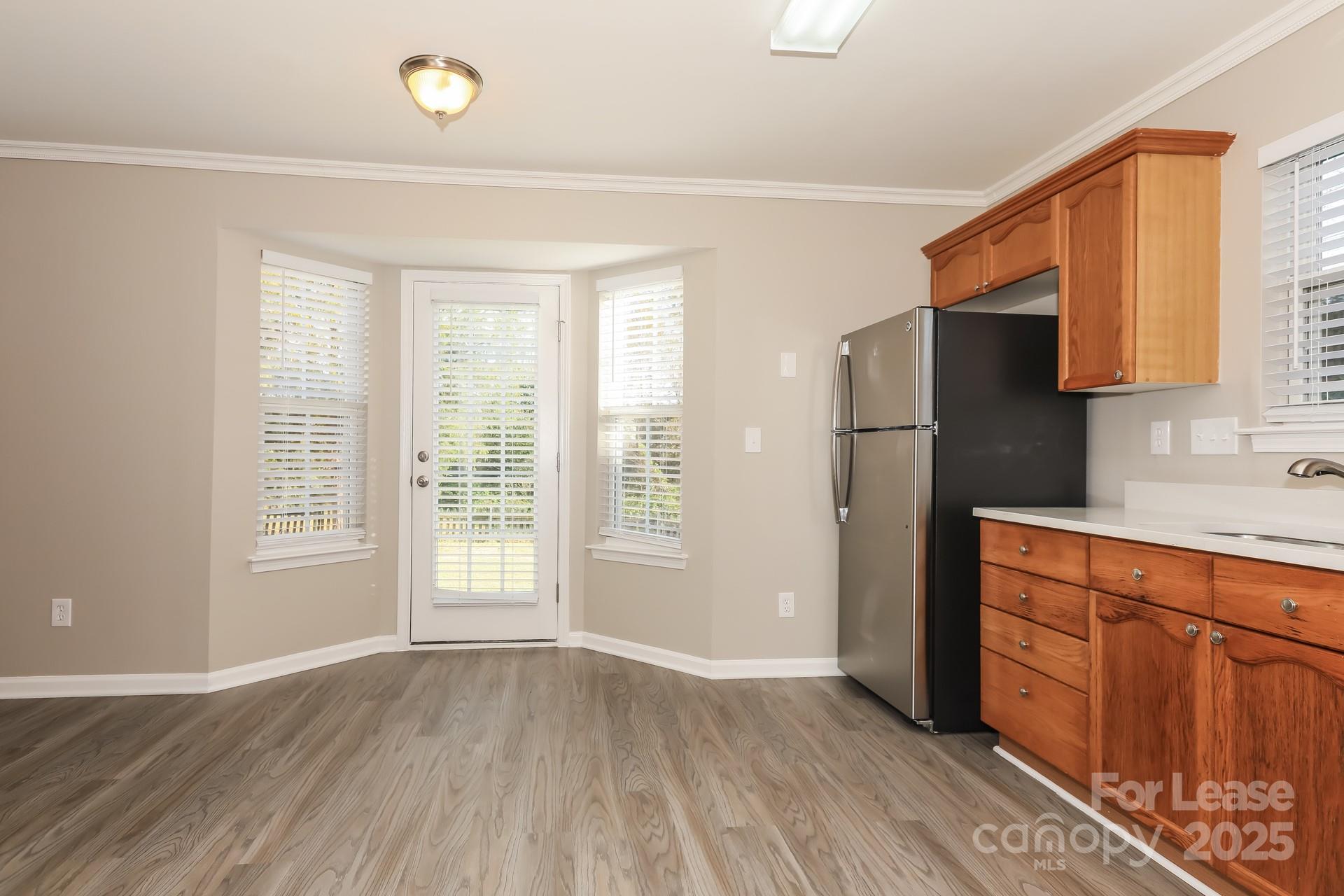 7037 Honey Tree Lane Indian Trail, NC 28079 - Photo 4 of 17 a kitchen with stainless steel appliances granite countertop a refrigerator a sink and wooden cabinets